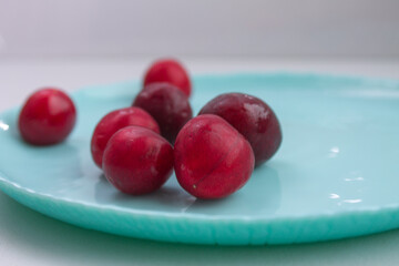 ripe cherries on a blue plate