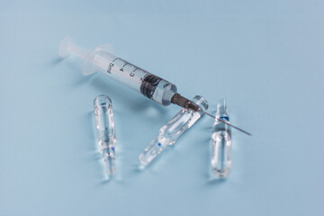 syringe and ampoule on a blue background. Vaccination