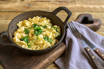 scrambled eggs with spinach in a cast-iron pan.