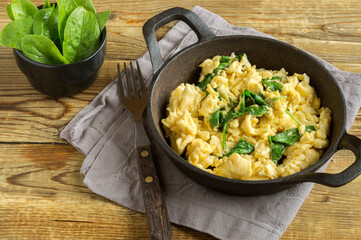 scrambled eggs with spinach in a cast-iron pan.