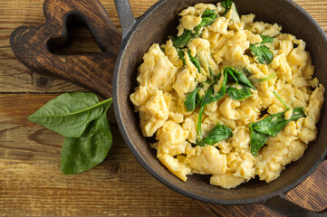 scrambled eggs with spinach in a cast-iron pan.