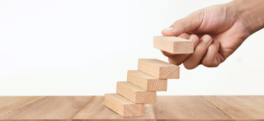 Hand arranging wood block stacking as step stair, Business concept growth success process