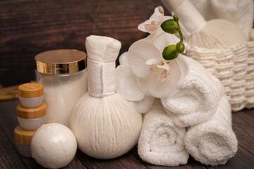 Fototapeta na wymiar Spa towels, cosmetics, and herbal compress