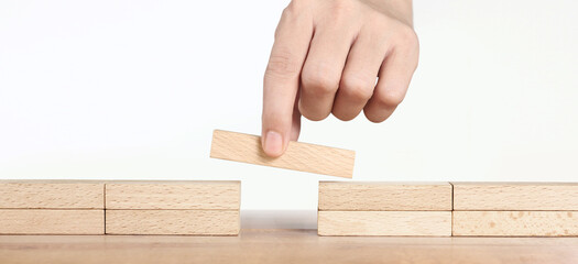 Hand placing wooden block, Planning of project management in business