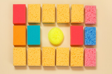 Sponges of different colors on a beige background.