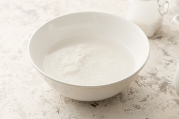 Bowl of rice water on light background