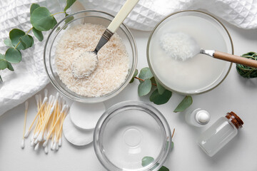 Healthy rice water with cosmetic supplies on white background