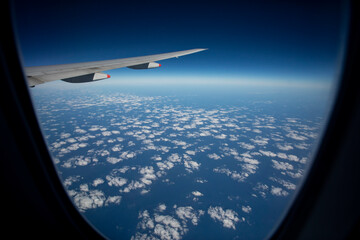 plane flying against blue sky and white cloud