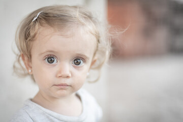 Retrato de niña rubia de ojos grandes mirando hacia la cámara