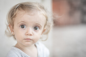Retrato de niña rubia de ojos grandes mirando hacia la cámara
