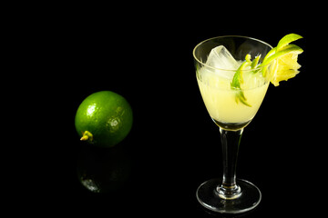 CAIPIRINHA OF LEMON A TYPICALLY BRAZILIAN DRINK, PHOTOGRAPHED ON A DARK GLASS TABLE