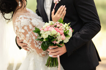 Newlyweds at wedding day, wedding couple with wedding bouquet of flowers, bride and groom