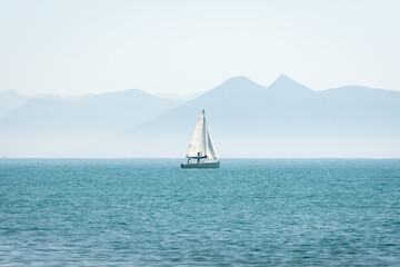 Fototapeta premium sailboat on the sea with mountains in the background