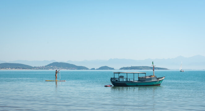 sea landscape with boat and stand up paddle board in brazil