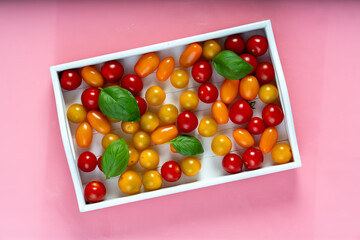 fresh italian cherry tomatoes on the vine in a wooden crate on a white background