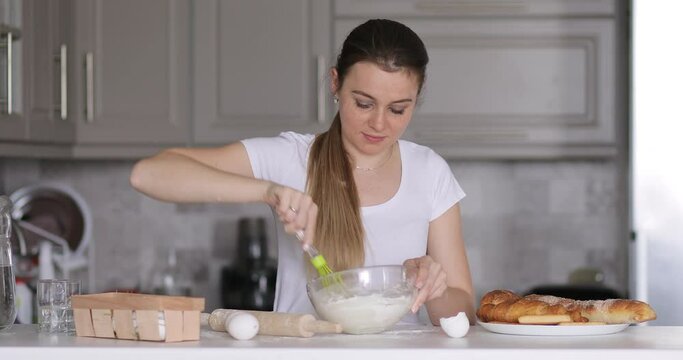 Happy young woman kneading dough for pizza with hands flour baking pastry at home, smiling lady housewife cooking in modern kitchen alone preparing pie cake or handmade cookies on table