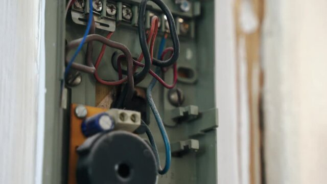 Close-up of old broken intercom, dusted wires and handset, vintage security system. Ancient interphone connection within a house, technology concept