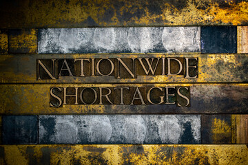 Nationwide Shortages text formed with real authentic typeset letters on vintage textured silver grunge copper and gold background