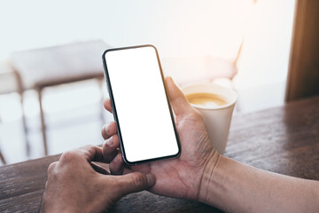 cell phone mockup image blank white screen.man hand holding texting using mobile on desk at coffee shop.background empty space for advertise.work people contact marketing business,technology