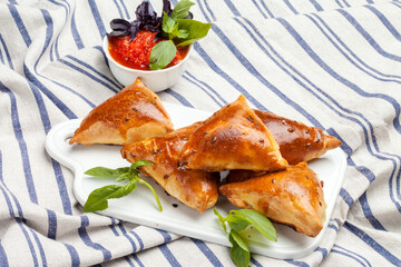 Samosas with tomato ketchup on a white plate, Indian street food, Ramadan iftar, Ramzan snacks.