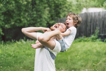 Obraz premium Father and his son playing and hugging in outdoors. Concept of Father's day. 