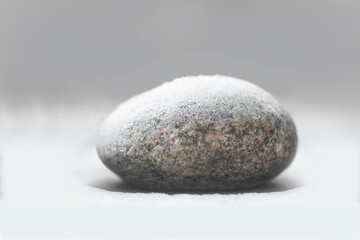 Fototapeta na wymiar round smooth rock with snow on top