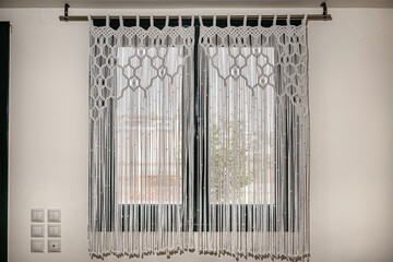 Handmade macrame white  curtain on the window