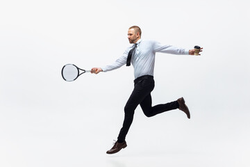 Time for movement. Man in office clothes plays tennis isolated on white studio background....