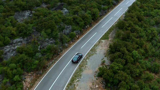 Car travels over mountain highway in Karlobag, Croatia. Aerial tracking view