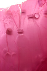ピンク色のビニール袋に入った空のペットボトル