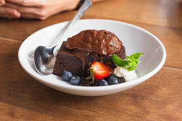 Homemade dark chocolate brownies topping with fresh fruits.