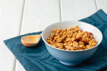 Bowl with granola on wooden table close up