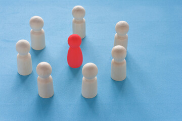 Red woman figure surrounded by circle of mans silhouettes on blue background. Gender discrimination and sexual violence concept. Female leader boss concept in a male team.