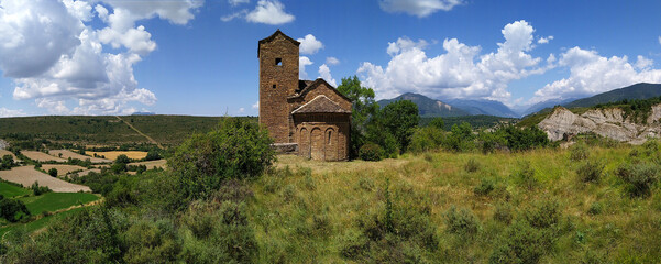 Fototapeta premium Landscape with view of the Romanesque Church of San Andres in the village of Satué. 11th century. Serrablo Region .Aragon. Spain.