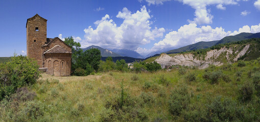 Fototapeta premium Landscape with view of the Romanesque Church of San Andres in the village of Satué. 11th century. Serrablo Region .Aragon. Spain.