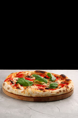 pizza with mushrooms, tomato and chicken closeup pizza with mushrooms and chicken on light concrete or stone table and black background for copy space