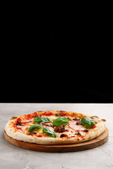 pizza with mushrooms and ham closeup on light concrete or stone table