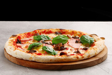 pizza with mushrooms and ham closeup on light concrete or stone table
