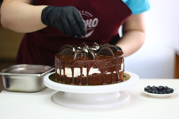 confectioner make and decorated cake on light table