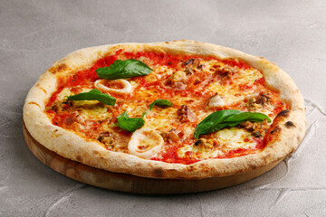 pizza with seafood closeup on light concrete or stone table top view. pizza with squid and mussels
