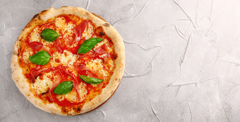 pizza prosciutto with basil and Mozzarella banner top view on light concrete or stone background