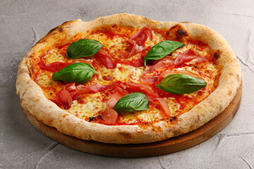 pizza prosciutto with basil and Mozzarella closeup on light concrete or stone background