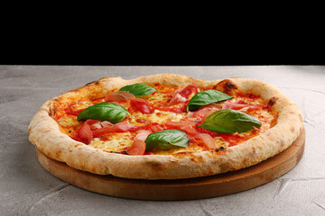 pizza prosciutto with basil and Mozzarella closeup on light concrete or stone background