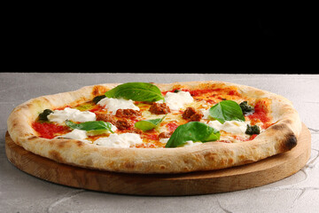 strachatella pizza closeup on light concrete or stone background. pizza with meat, pesto, tomatoes and stracciatella cheese