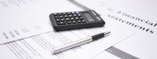 calculator, pen, and financial statement