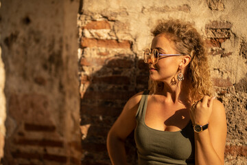 Obraz premium Young woman posing in front of ruined old wall