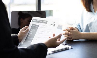 Asian female leader is interviewing new job applicants in the meeting room.