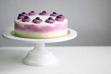blueberry cream cake close up on light background. white and purple cake