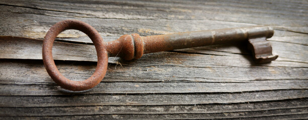 Rostiger alter Schlüssel auf einem alten Holzbrett