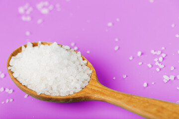 Sea salt crystals close-up in macro mode on a pink background.